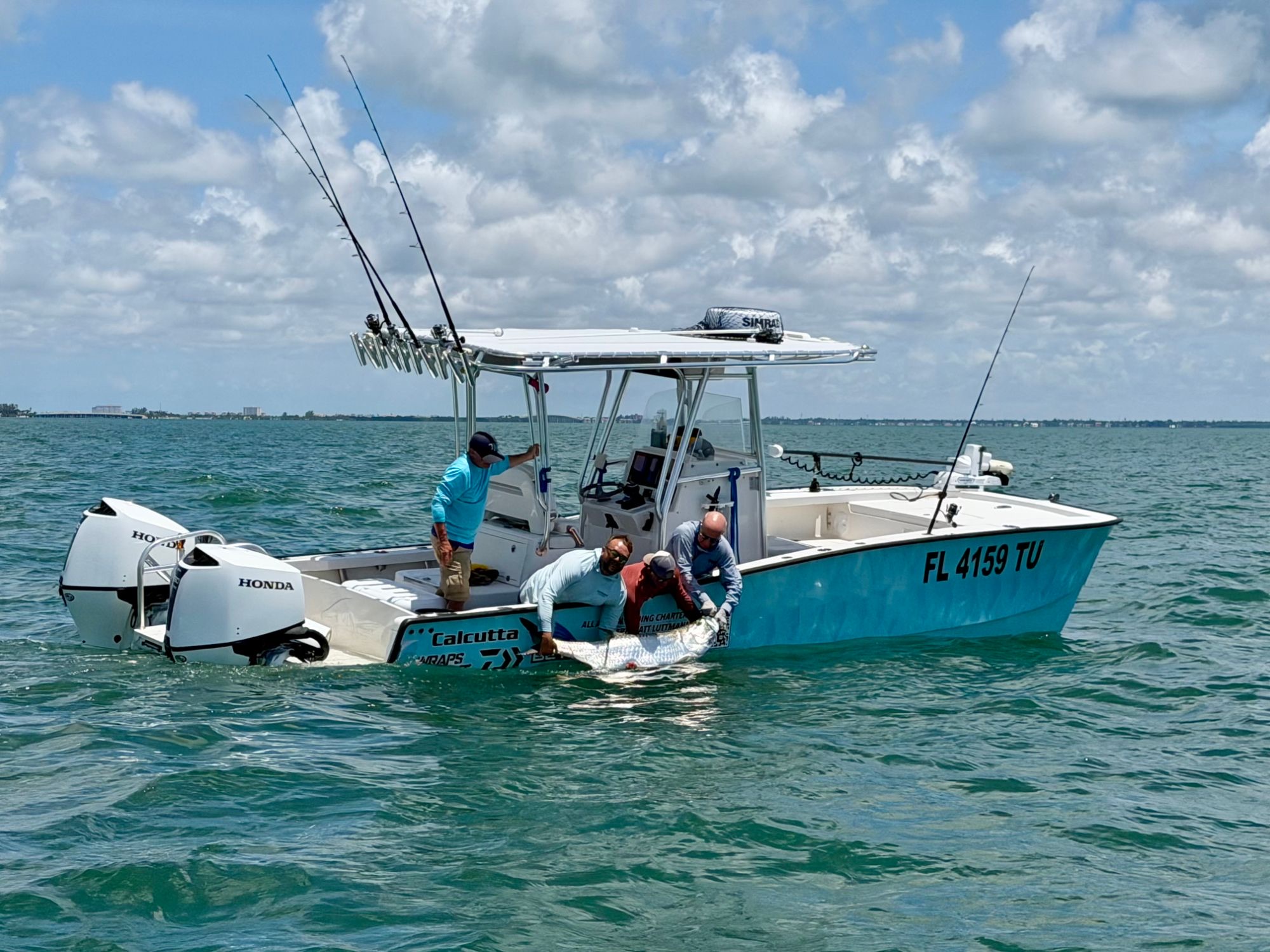 Capt. Matt Luttmann and clients releasing a tarpon boat-side from his center console off St. Petersburg